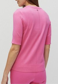 Kurzärmliger rosa Pullover aus Strickstoff, mit rundem Ausschnitt und einem Knopfdetail am Rücken sowie einem klaren Nahtdesign.
