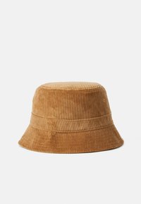 Cappello a secchiello in corduroy marrone con una larga visiera, caratterizzato da una texture a coste verticali e una corona strutturata. Nessun logo o abbellimento visibile.
