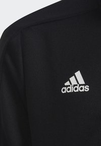 Sudadera deportiva negra con una tela texturizada, que presenta un destacado logo blanco de Adidas en el pecho.