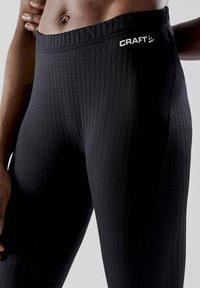 Black ribbed leggings with an elastic waistband and white "CRAFT" logo on the front. Material is stretchy and fitted.
