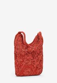 Red crochet handbag with floral pattern, open weave texture, and two handles. Compact rectangular shape, emphasizing intricate detailing.