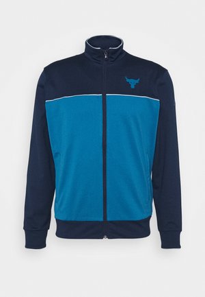 Marineblaue und blaue Jacke mit Reißverschluss, hohem Kragen, langen Ärmeln und kleinem Bullen-Logo auf der oberen linken Brust.