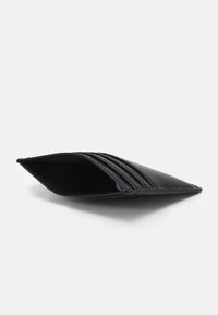 Portafoglio in pelle nera con una superficie liscia, caratterizzato da molteplici scomparti per carte e un design aperto. Forma curva e allungata con un bordo cucito.