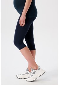 Marine capri's van rekbare stof, met een aansluitend ontwerp. Gepaard met witte en grijze sportschoenen met gaasdetails en een stevige zool.