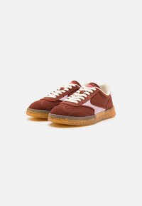 Baskets en suede rouge foncé avec des accents rose clair, lacets blancs plats et une semelle en caoutchouc transparent. Comprend des motifs brodés et une forme arrondie.