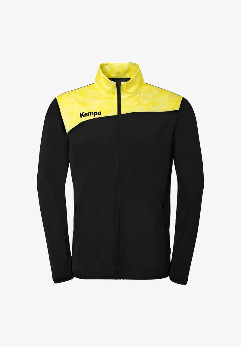 Veste noire zippée avec empiècement et col à motif géométrique jaune, portant le nom de la marque "Kempa" sur le côté gauche de la poitrine.