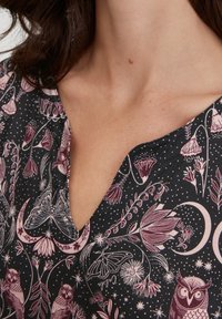 Tessuto nero con un motivo floreale e celeste in color bordeaux e crema, con gufi e farfalle, caratterizzato da un design a V.