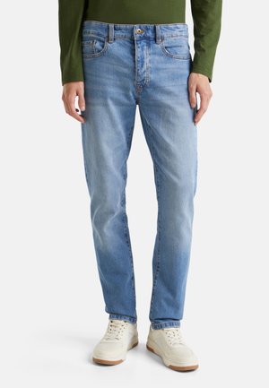 Lichtblauwe denimjeans met een rechte snit, met vijf zakken, contrasterend stiksel en een knoopsluiting. Gemaakt met witte sneakers.