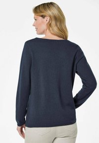 Dunkelblauer Pullover mit langen Ärmeln, weitem Ausschnitt und weicher Strickstruktur. Verfügt über eine lässige Passform mit gerippten Bündchen.