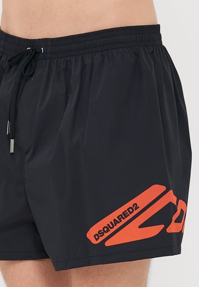 Schwarze Schwimmshorts mit elastischem Bund und Kordelzug, mit großem roten "DSQUARED2"-Logo am linken Bein.