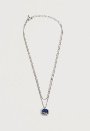 Collier à double chaîne en argent avec pendentif carré en pierre bleue présentant des taches blanches et dorées dans un cadre en argent.