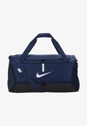 Navy blue duffel bag made of durable fabric, features a white Nike logo, dual top handles, and an adjustable shoulder strap, with zippered compartments.