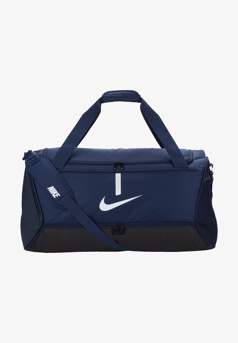 Mørkeblå duffelbag lavet af slidstærkt stof, har et hvidt Nike-logo, to top-håndtag og en justerbar skulderrem, med lynlåslommer.