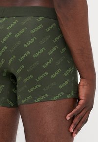 Gröna boxershorts med ett upprepande mönster av Levi's logotyp i en kontrasterande ljusgrön nyans, med en bekväm elastisk midjeband.