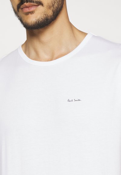 Camiseta de algodón blanca con cuello redondo y el logotipo manuscrito "Paul Smith" bordado en azul marino en el lado izquierdo del pecho.