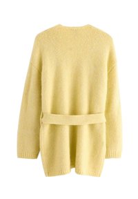 Gul strikket cardigan med tekstureret finish, åben front, og et stofbælte i taljen. Har sænkede skuldersømme og ribbede manchetter.