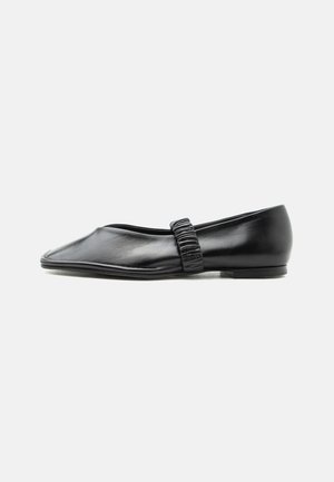 Scarpa piatta in pelle nera con cinturino arricciato sulla parte superiore e punta leggermente appuntita, mostrata su uno sfondo semplice.