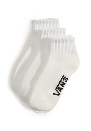 Tres pares de calcetines blancos hasta el tobillo con puños acanalados, apilados, con el logo negro de Vans en el lateral.
