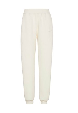 Pantalones deportivos de color crema con textura acanalada, cintura elástica y puños, con un pequeño detalle de logo en el muslo.