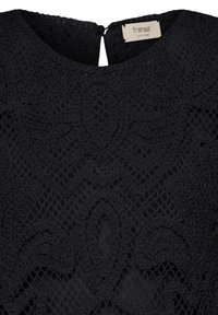 Top en dentelle noire avec des motifs floraux complexes, col rond et fermeture par bouton dans le dos, avec une étiquette de marque "fransa".