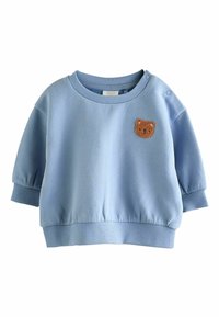 Svetlomodrá detská mikina s rebrovanými manžetami, lemom, výstrihom, patentkami na ramene a malou hnedou nášivkou s medvedíkom na hrudi.
