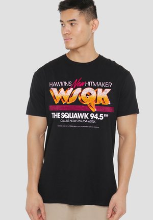 Black cotton T-shirt featuring bold, colorful text and radio station graphics. Crew neck, short sleeves, and a relaxed fit.