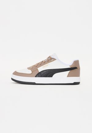 Sneakers met een bovenwerk van wit, bruin en zwart leer, voorzien van een zwarte zijkantstreep, een getextureerde neus en een rubberen zool.