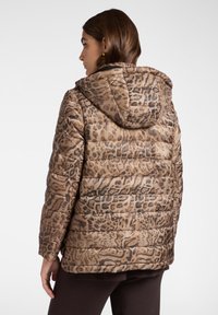 Giacca imbottita marrone con un motivo a stampa leopardata, dotata di cappuccio e design a righe orizzontali. Texture liscia e materiale leggero.