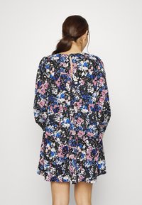 Vestido floral com mangas longas, base preta, apresentando padrões em azul e rosa. A vista traseira mostra uma abertura em formato de olho-chave na gola.