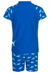 Conjunto de t-shirt e calções azul, feito de poliéster, com um padrão de tubarões. A t-shirt tem mangas curtas; os calções são decorados com tubarões em azul claro.