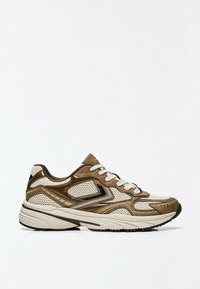 Chaussure de sport en mesh marron et beige avec lacets blancs, semelle épaisse et semelle extérieure noire, vue de profil sur fond blanc.