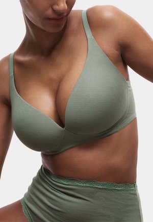 Bralette de algodón verde con escote pronunciado, tirantes ajustables y diseño sin costuras, combinado con pantalones cortos a juego con detalles de encaje.