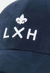 Marineblaues Cap mit weißen gestickten Buchstaben "L X H" und einem Lilien-Symbol. Hergestellt aus weichem Stoff mit sichtbaren Nähedetails.