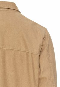 Khaki overhemd van een gladde, gestructureerde stof, met een puntige kraag en achterpand. Het ontwerp is eenvoudig met nette stiksels.
