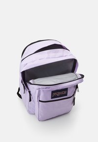 Šviesiai violetinė Jansport kuprinė, pagaminta iš audinio su lygiu paviršiumi. Turi didelį pagrindinį skyrių ir priekiniame skyriuje su užtrauktuku. Juodi akcentai.