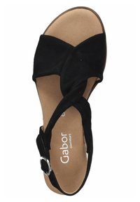 Sandale en daim noir avec des brides croisées, bout ouvert et boucle ajustable. Semelle intérieure beige douce avec la marque "confort Gabor".