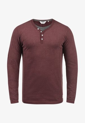 Cămașă henley cu mânecă lungă, de culoare burgundă, cu decolteu în V, placket cu trei butoane și textură moale. Prezentând un guler de culoare gri în contrast.