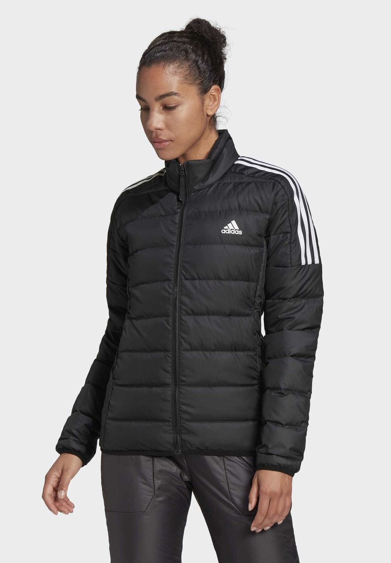 Chaqueta de plumas negra con diseño acolchado, cuello alto, cierre frontal y acentos de tres rayas blancas en los hombros. Logo en el lado izquierdo del pecho.