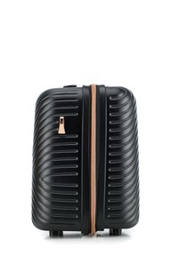 Valigia a mano rigida nera con scanalature verticali, una cerniera in rosé dorato e quattro ruote per la mobilità alla base.