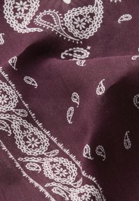 Bordeaux bomuld bandana med hvide paisley og blomster mønstre, med indviklede blonder-lignende kanter og en blød, tekstureret finish.
