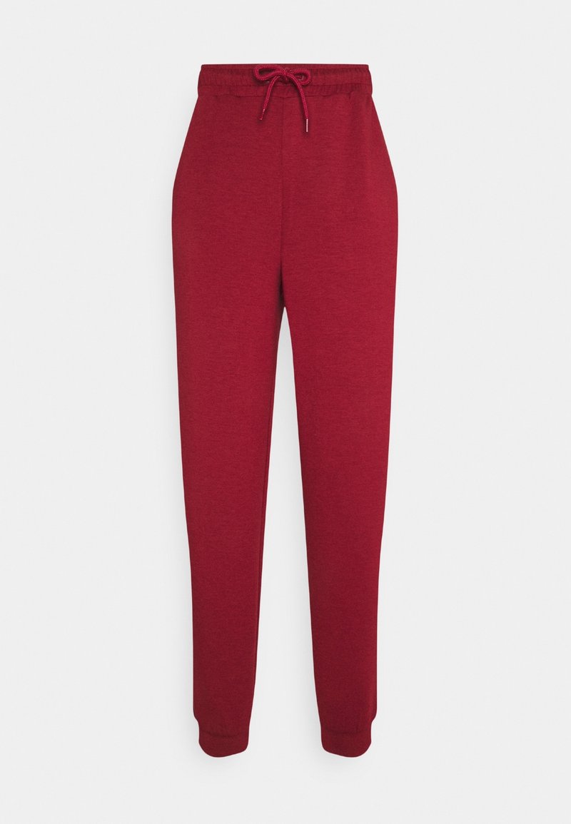 Pantalon de jogging en coton rouge avec taille élastique et cordon, jambes fuselées et poignets côtelés.