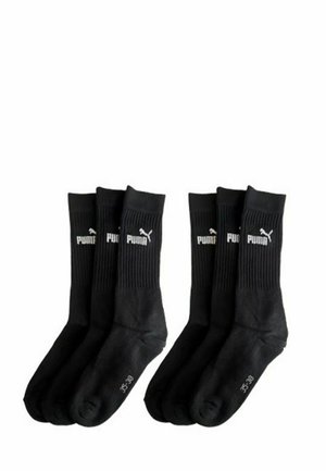 Sechs schwarze Puma Crew-Socken, mit geripptem oberen Teil, weißem Puma-Logo und Größenmarkierungen auf der Sohle, angeordnet in zwei Gruppen zu je drei.