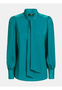 Türkosa blus med knytkrage, långa puffärmar och skrynkliga manschetter, tillverkad av slätt tyg utan synliga mönster eller dekorationer.