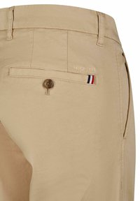 Beige chino's met een gladde textuur, voorzien van een knoopzak op de achterkant, subtiele logo-geborduurde details en een drie-kleurenaccent.