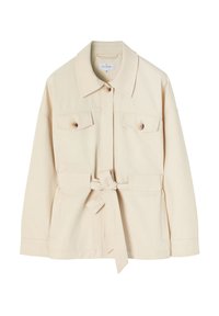 Beige käyttötakki, joka on valmistettu puuvillasta. Takissa on kaulus, kaksi etutaskua, napit ja säätövyö vyötäröllä.