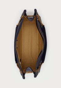 Mornarica kožna torba s zlatnim lančićima. Otvoreni interijer s bež podlogom i višestrukim džepovima za organizaciju. Strukturalni oblik.