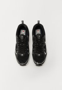 Black athletic shoes made of mesh and synthetic materials, featuring a sleek design, round toe, and reflective accents on the sides.