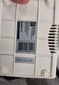 Witte LED-lamp met een gladde, rechthoekige vorm, voorzien van een streepjescode en labels. Zijkanten met ventilatieopeningen voor luchtstroom en een ronde knop aan de onderkant.