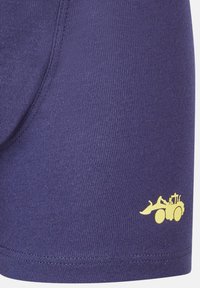 Violet puuvillabokserid, mille vasakul küljel on kollase ehitusmasina graafika, sile tekstuur ja elastne vöökoht.