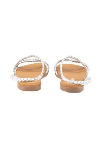 Sandalias planas con tiras de plata trenzadas, plantilla acolchada marrón y un tacón bajo. Diseño simple y minimalista, adecuado para uso casual.